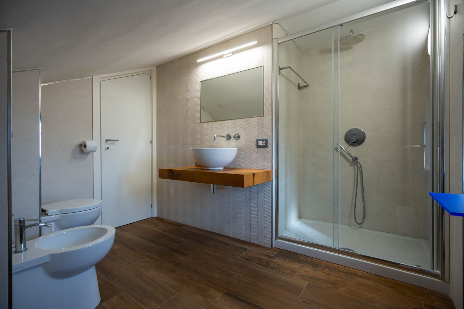 Bagno privato della Camera Zeus con doccia e lavabo in legno